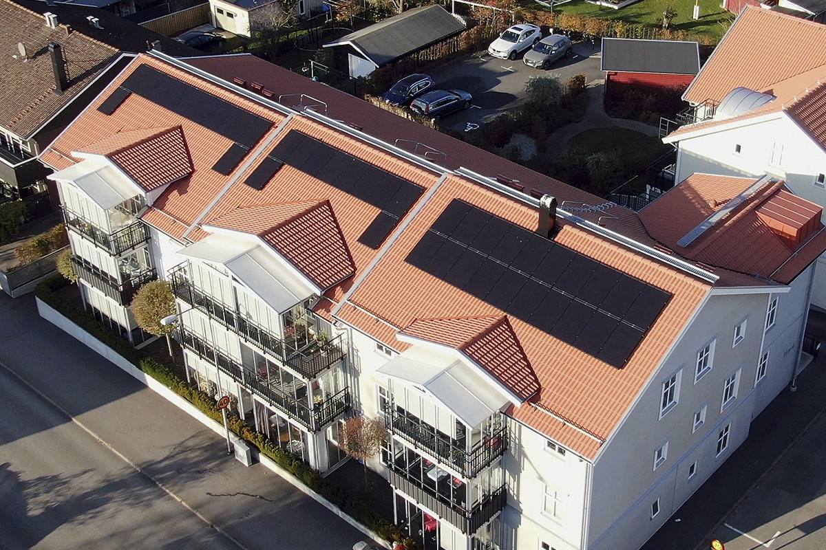 flerfamiljshus med solceller på taket sett uppifrån